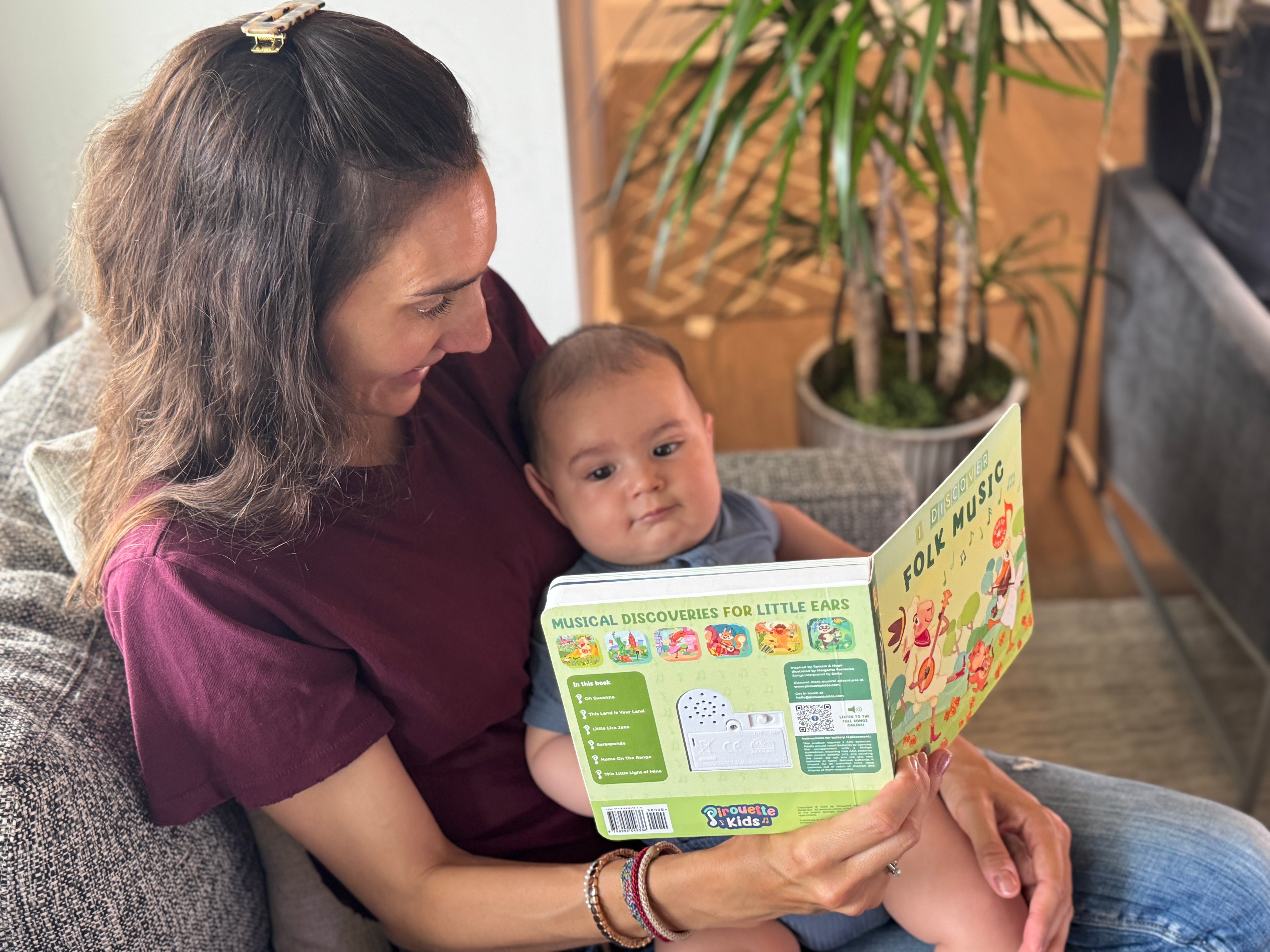 Baby and mom reading folk music book by Pirouette Kids