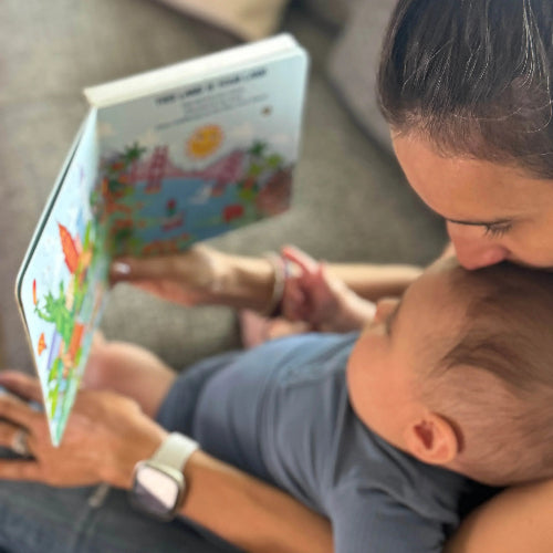 Baby and mother reading "I Discover Folk Music" interactive music book for babies and toddler