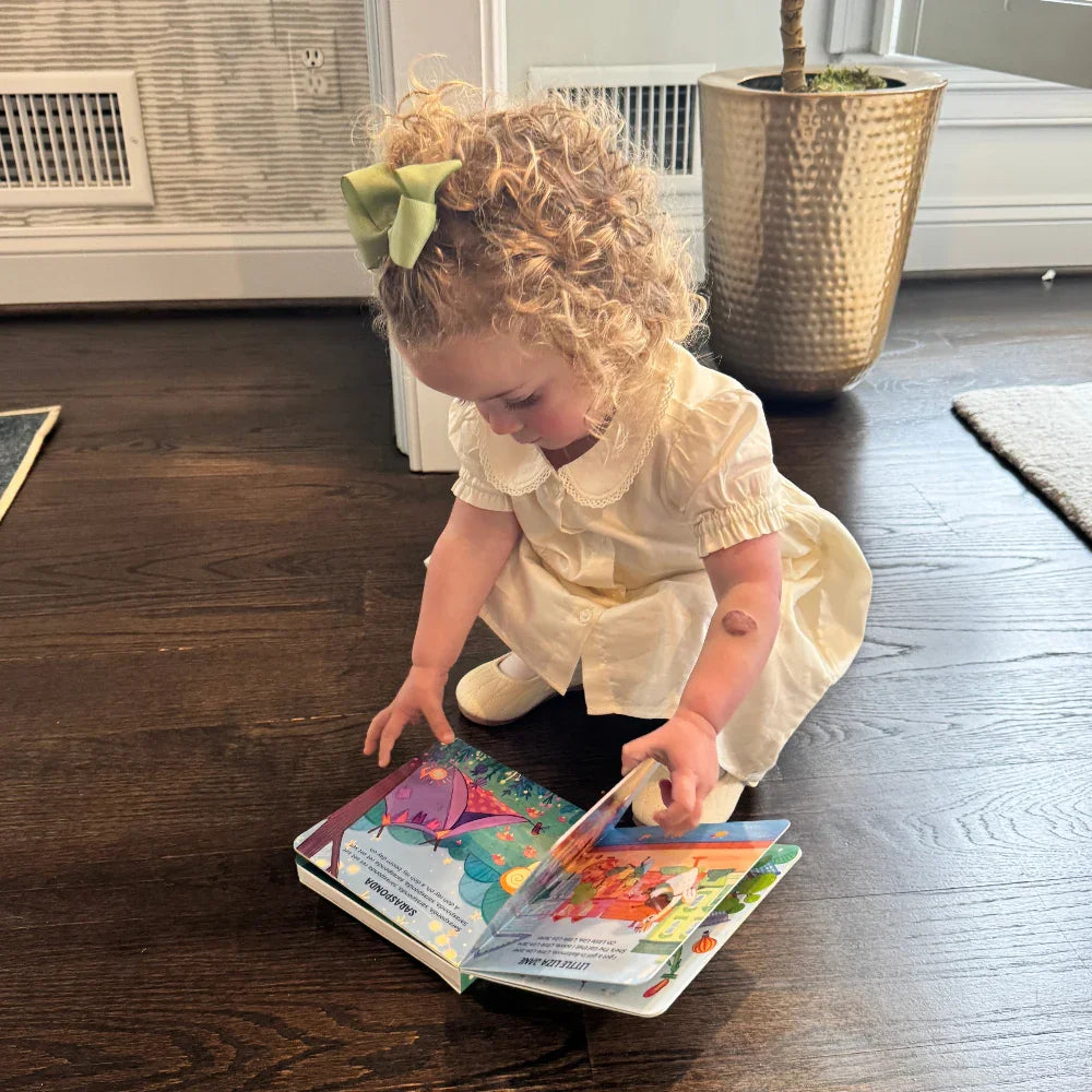 little girl reading folk music book by Pirouette Kids