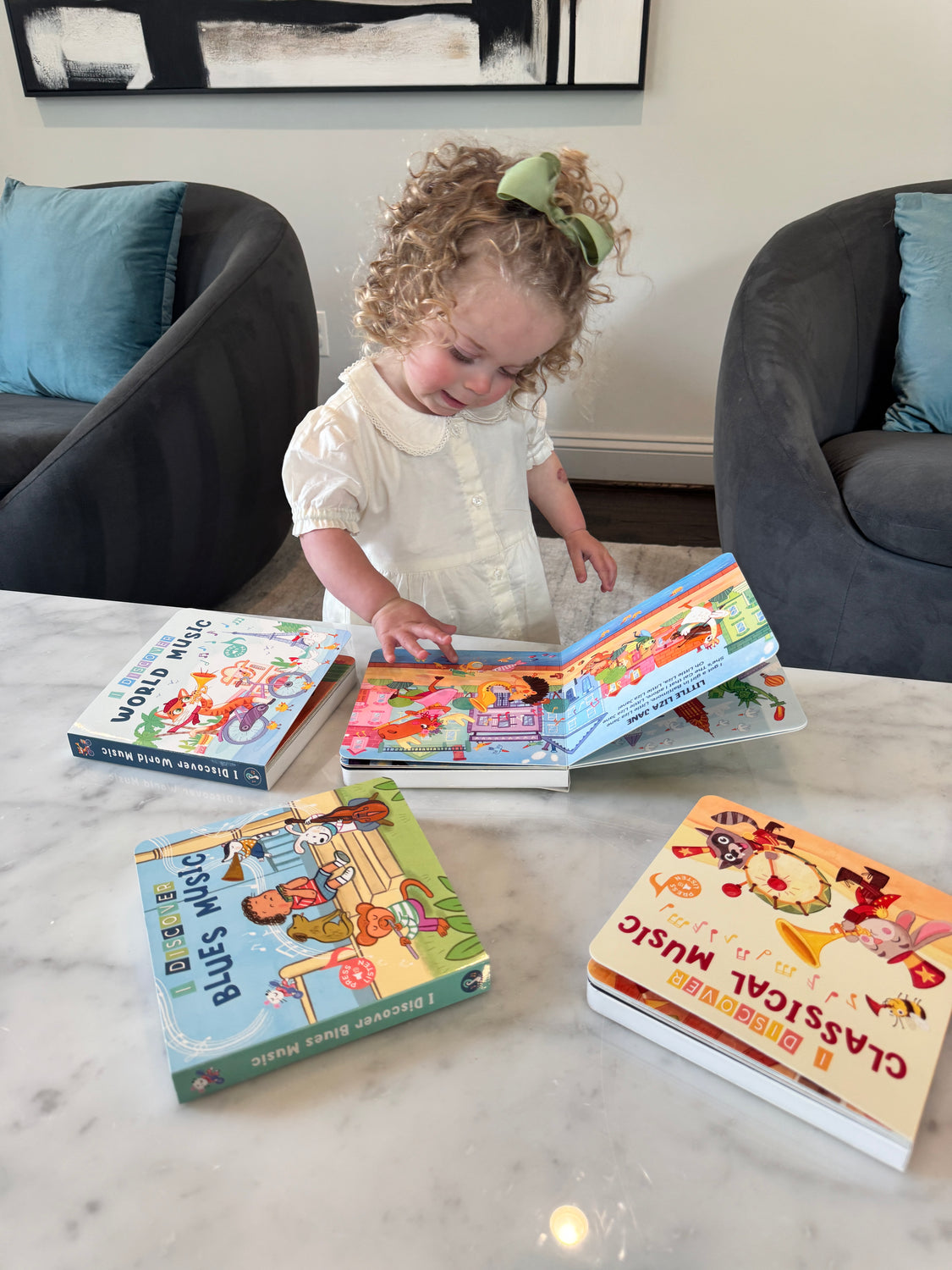 Toddler pressing button on folk music book by Pirouette Kids