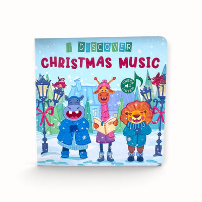 A children's board book titled 'I Discover Christmas Music' featuring a colorful winter illustration of three singing animals in a snowy street scene.